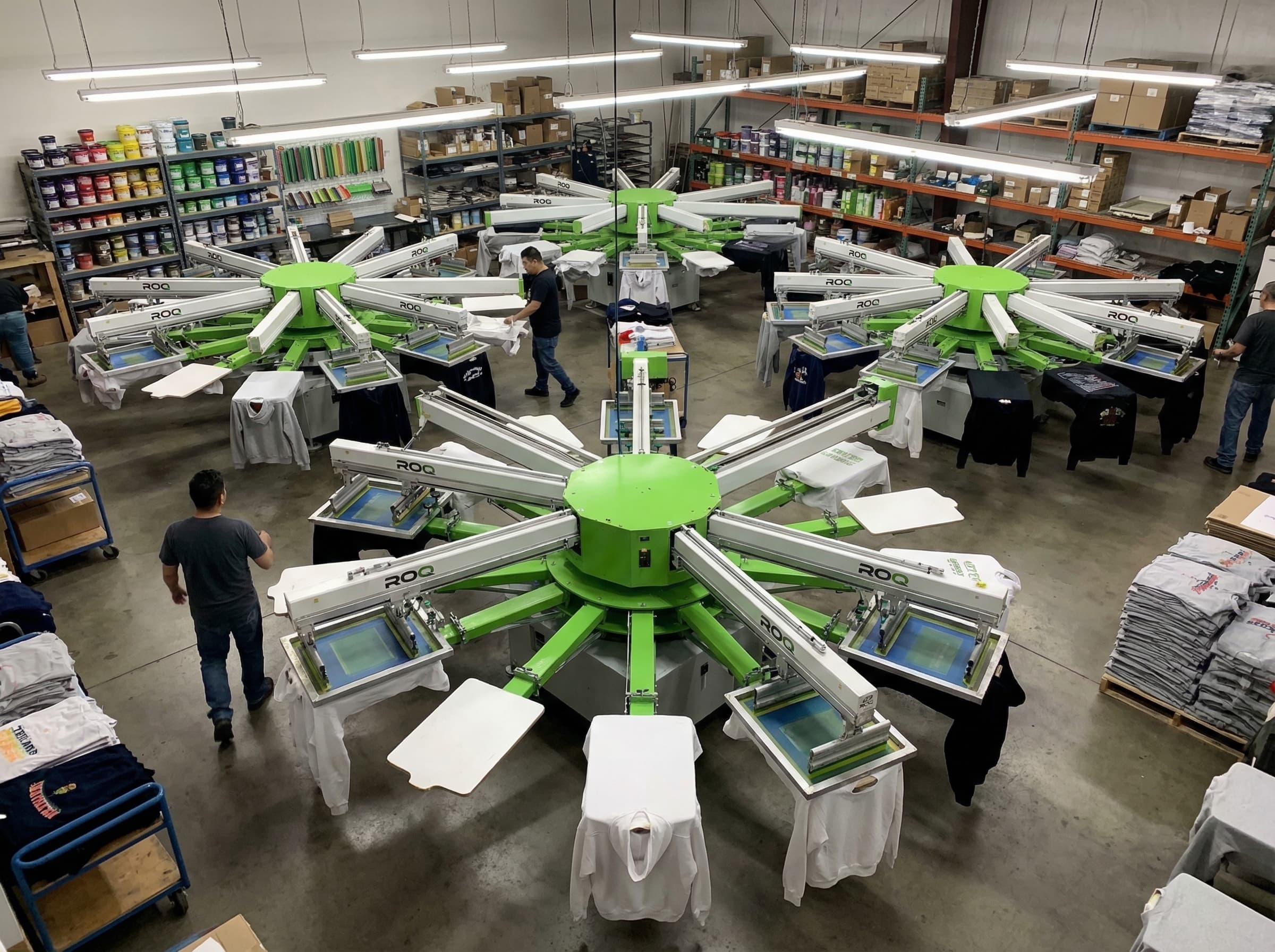ROQ automatic rotary screen printing press with neon green ink printing on black t-shirts
